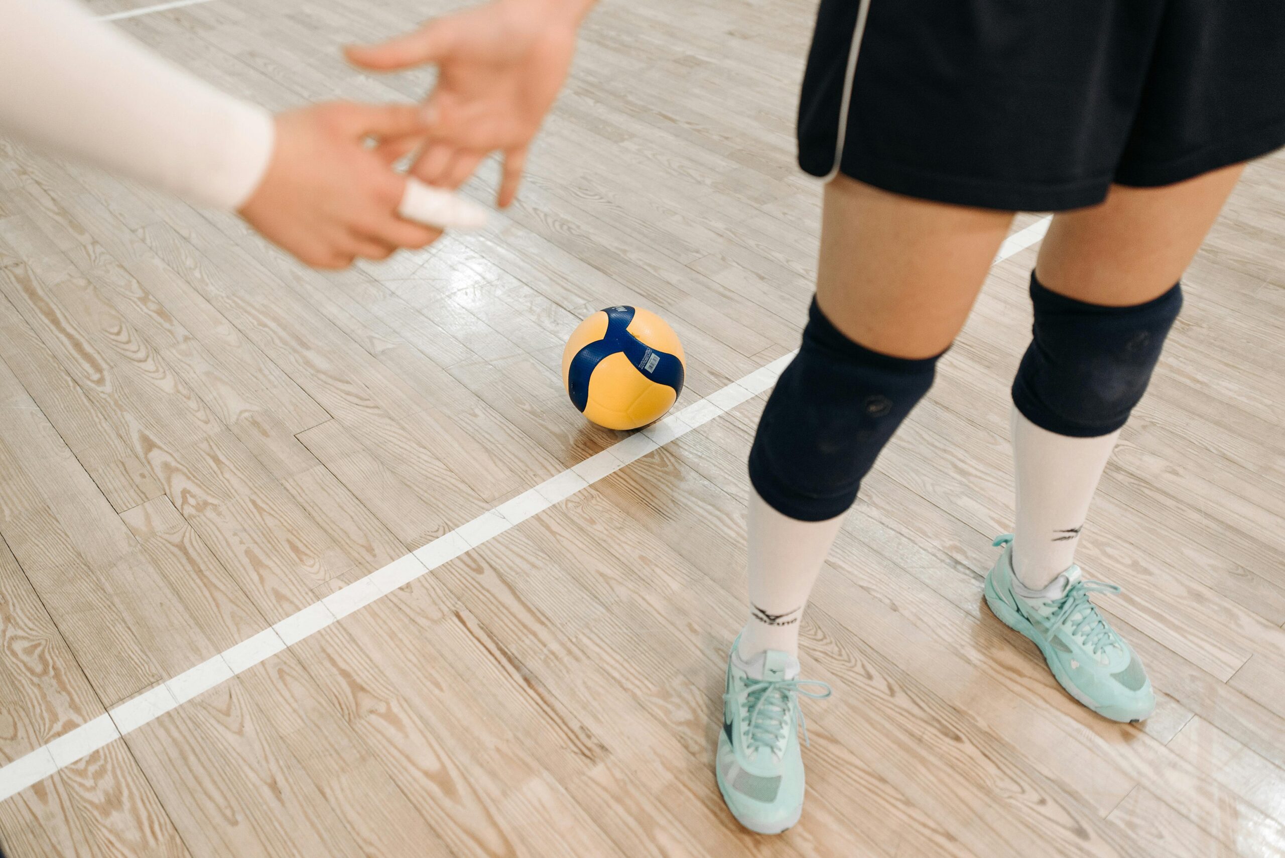 Home Close-up of volleyball players ready for action on an indoor court.